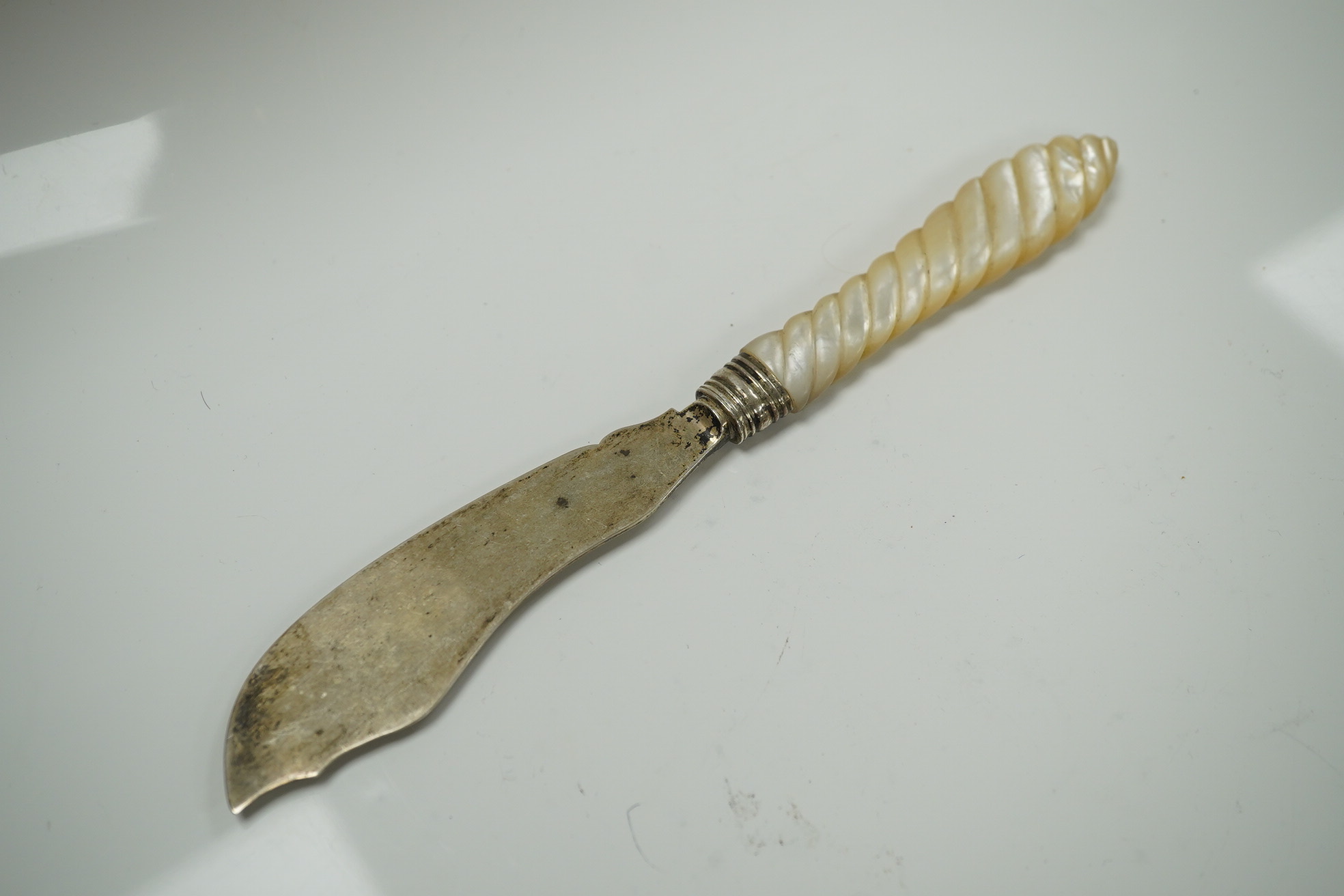 Two Victorian mother of pearl handled butter knives and a Victorian Scottish silver fiddle pattern basting spoon. Condition - fair